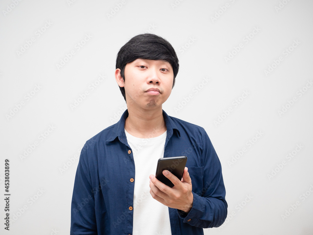 Young man holding cell phone feeling bored emotion portrait white isolated Young man holding cell phone feeling bored emotion portrait white isolated