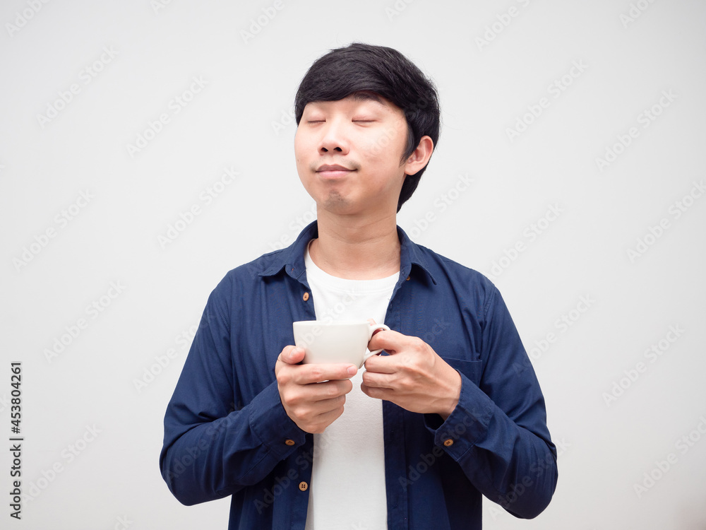 Asian young man holding coffee cup feeling relax Asian young man holding coffee cup feeling relax