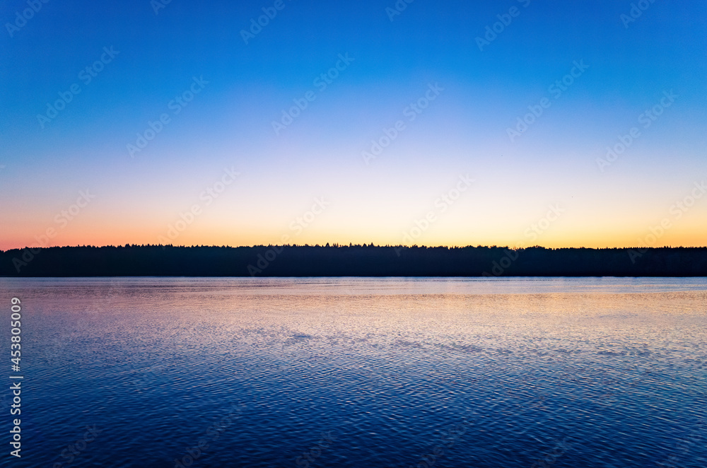 Tranquil minimalist landscape with a smooth lake surface with calm waters with a horizon and clear skies. Simple beautiful natural calm background. Copy space Tranquil minimalist landscape with a smooth lake surface with calm waters with a horizon and clear skies. Simple beautiful natural calm background. Copy space
