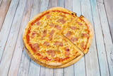 Carbonara recipe family pizza with fried bacon, oregano, tomato and mozzarella cheese on wooden board