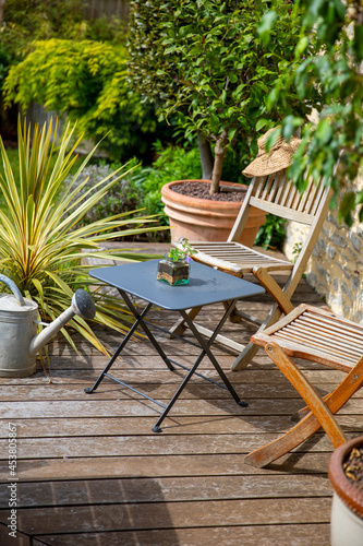 Fotografiet Salon de jardin sur une terrasse en bois au printemps.