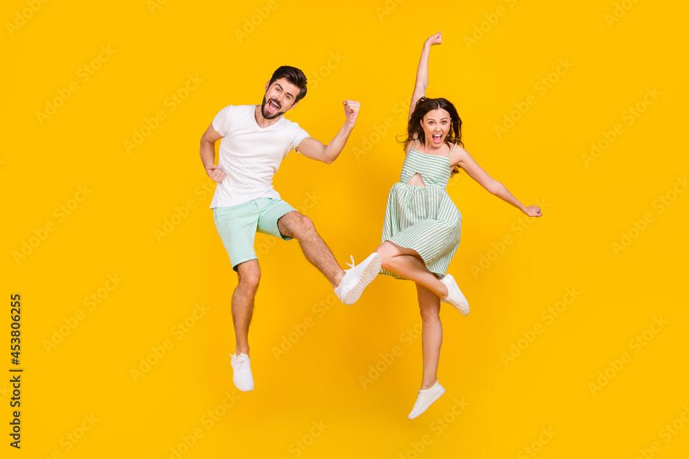 Photo of sporty champion couple jump celebrate victory wear casual outfit isolated yellow color background