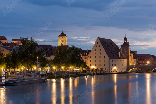 Town hall tower of Regensburg and Salzstadel on the banks of the Danube river with Stone Bridge at night