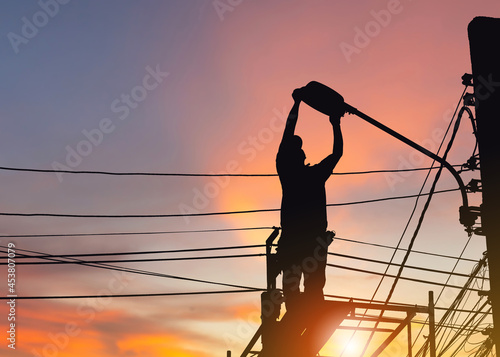Foto Silhouette of Electrician checking lighting to the LED street lamp post, Technic