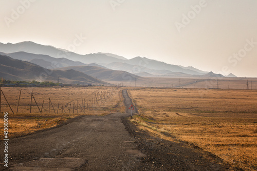 Dirt road in Uzbekistan with mountain views at sunset