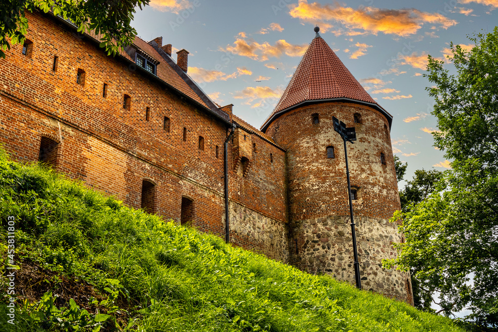 Defense walls and tower of medieval gothic Bytow Castle of Teutonic Order and Pomeranian Dukes in historic city center in Poland - obrazy, fototapety, plakaty 