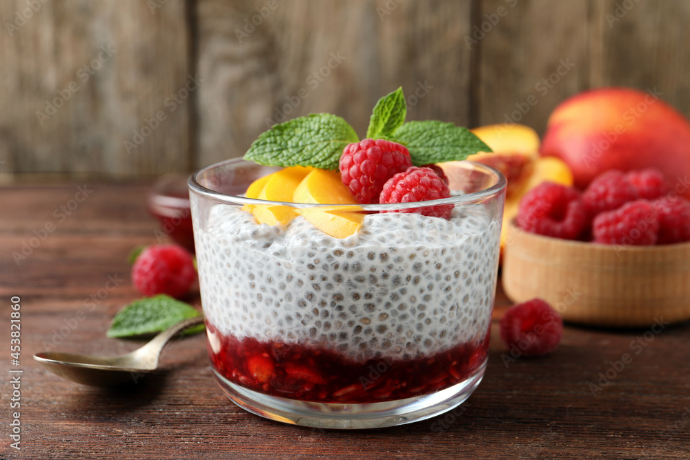 Delicious chia pudding with raspberries, peach and mint on wooden table Delicious chia pudding with raspberries, peach and mint on wooden table