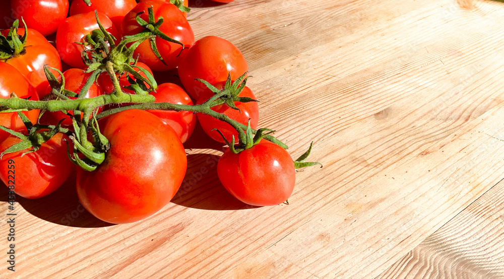 Red tomatoes on wooden background. Fresh vegetables top view with copy space for text. Flat lay. The concept of the harvest, vegetable garden. Natural products, agriculture. Lay out Red tomatoes on wooden background. Fresh vegetables top view with copy space for text. Flat lay. The concept of the harvest, vegetable garden. Natural products, agriculture. Lay out