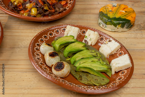 Mexican food. order of avocado with nopal and onion served in an earthenware plate on a wooden table