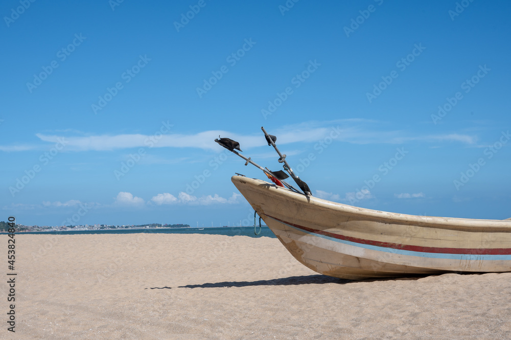 Striped boats docked on the beach, blue sky, sea and beach Striped boats docked on the beach, blue sky, sea and beach