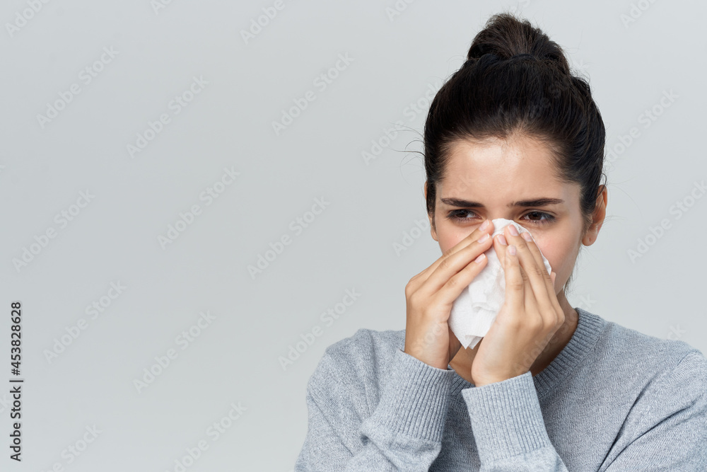 woman wiping her nose with a handkerchief flu health problems treatment woman wiping her nose with a handkerchief flu health problems treatment