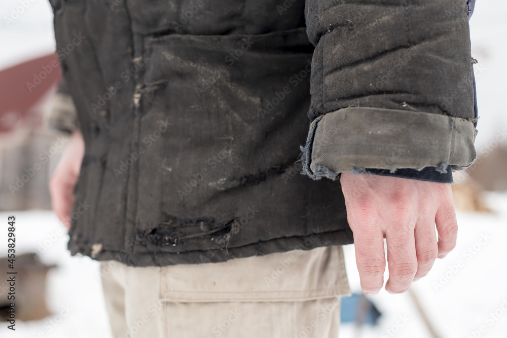 Man hand in an old shabby sweatshirt. Traditional, winter, warm clothes in the countryside, in Russia.