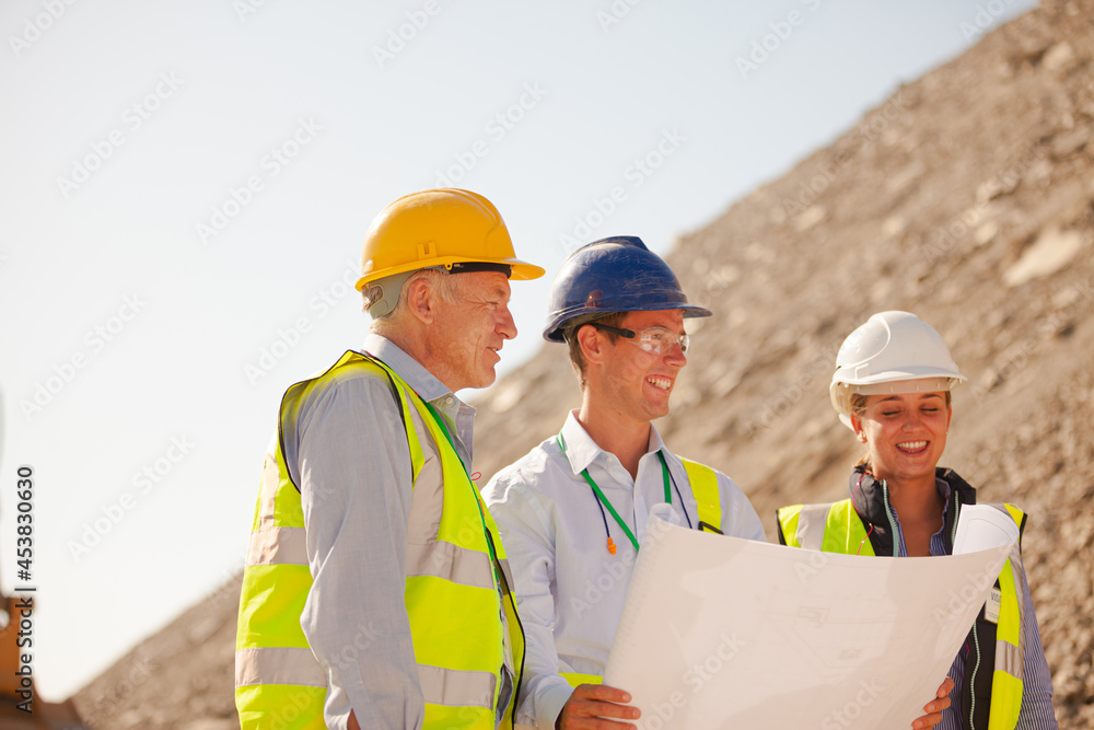 Business people and workers standing in quarry Business people and workers standing in quarry