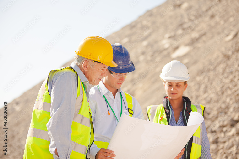Business people and workers standing in quarry Business people and workers standing in quarry