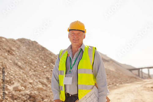 Businessman and worker reading blueprints on site
