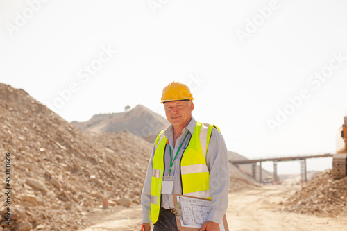 Businessman and worker reading blueprints on site