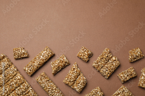 Pieces of delicious kozinaki bars on brown background, flat lay. Space for text