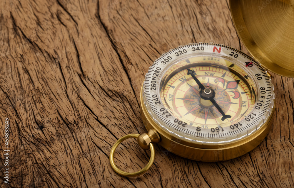 Vintage compass, navigational compass on wooden background
