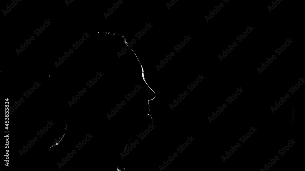 Halo outline glowing light behind head of man in the dark Halo outline glowing light behind head of man in the dark
