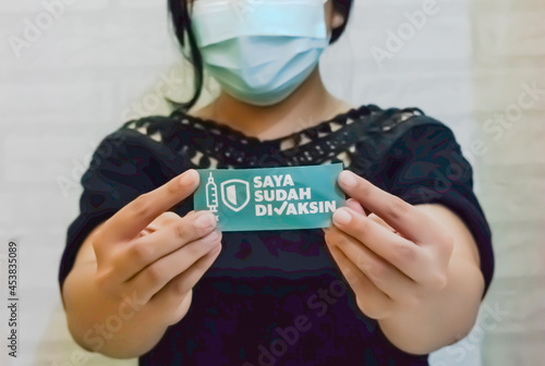 a woman holding a sticker that says I've been vaccinated © ijuf