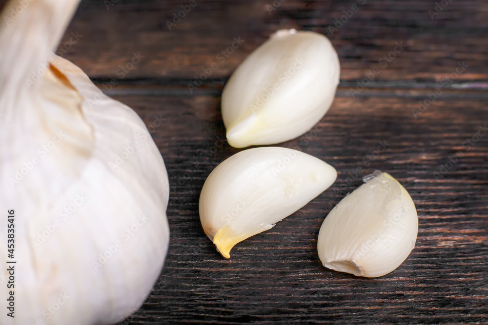Garlic cloves and head close-up on a wooden background Garlic cloves and head close-up on a wooden background