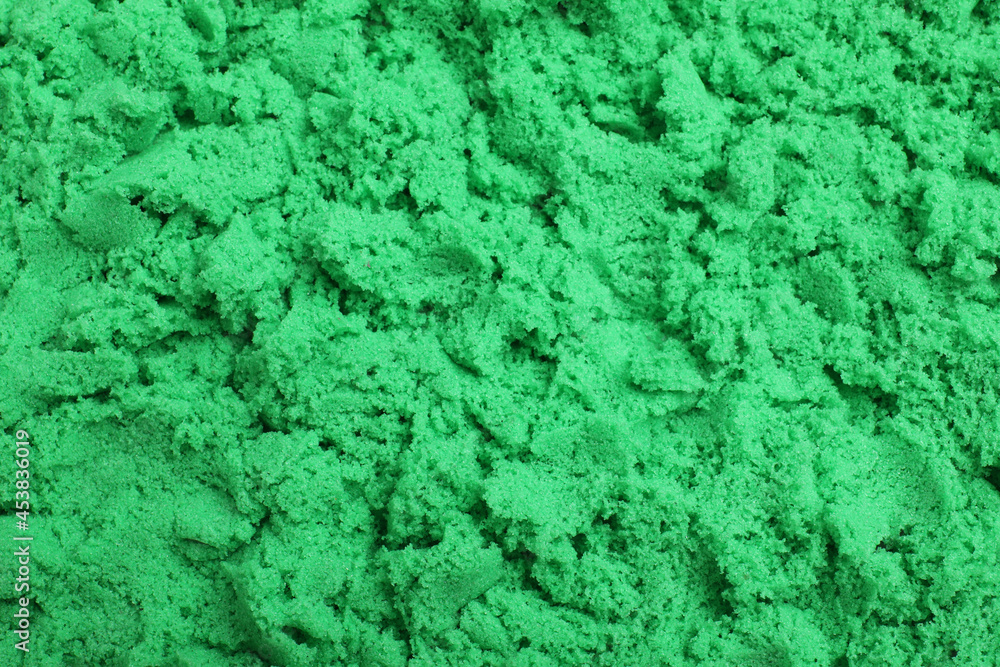 Green kinetic sand as background, closeup view