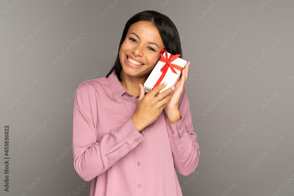 Excited grateful woman with gift in decorated wrapped box. Happy mixed race female get present for birthday, xmas or new year, salary bonus at work, discount for shopping. Celebration event concept Excited grateful woman with gift in decorated wrapped box. Happy mixed race female get present for birthday, xmas or new year, salary bonus at work, discount for shopping. Celebration event concept