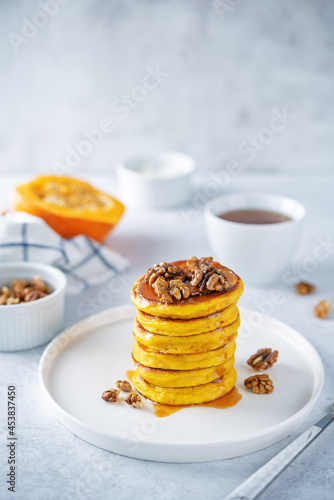 Pumpkin pancakes with walnuts and caramel sauce in a plate