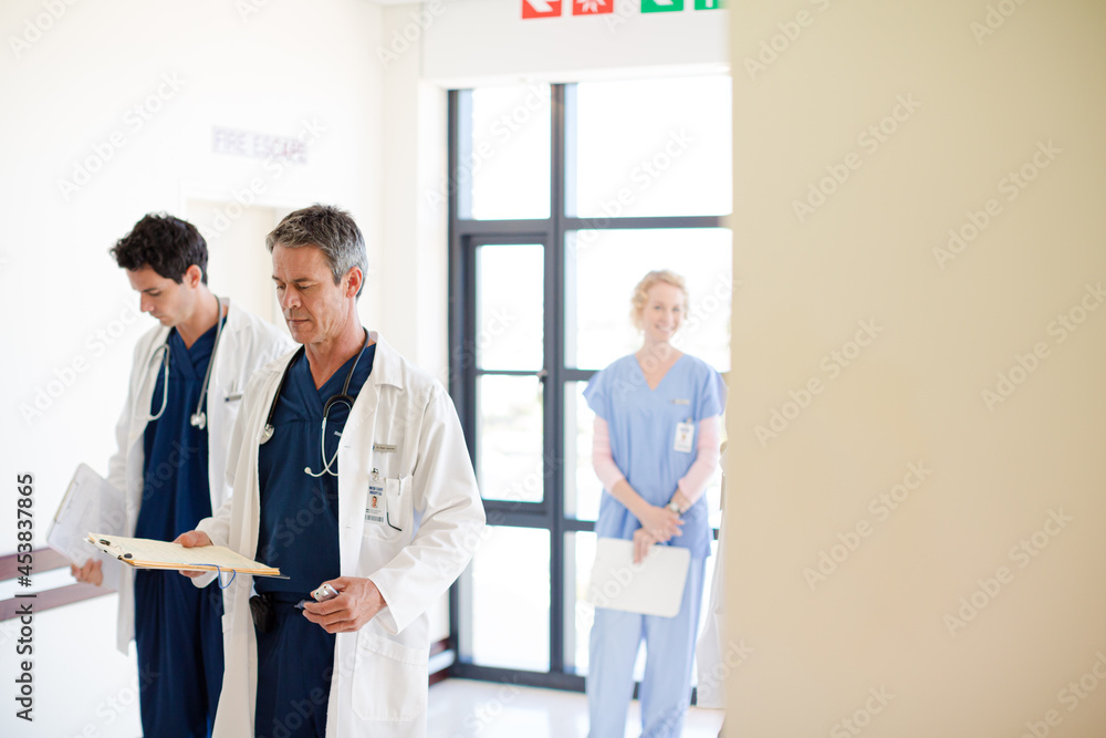 Doctors and nurses walking down hospital corridor Doctors and nurses walking down hospital corridor