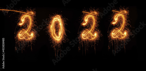 Welcome year 2022 written with a sparkler on black background