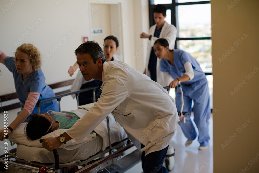 Doctors rushing patient on gurney in hospital corridor Doctors rushing patient on gurney in hospital corridor