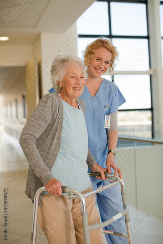 Nurse helping senior patient with walker in hospital corridor © KOTO