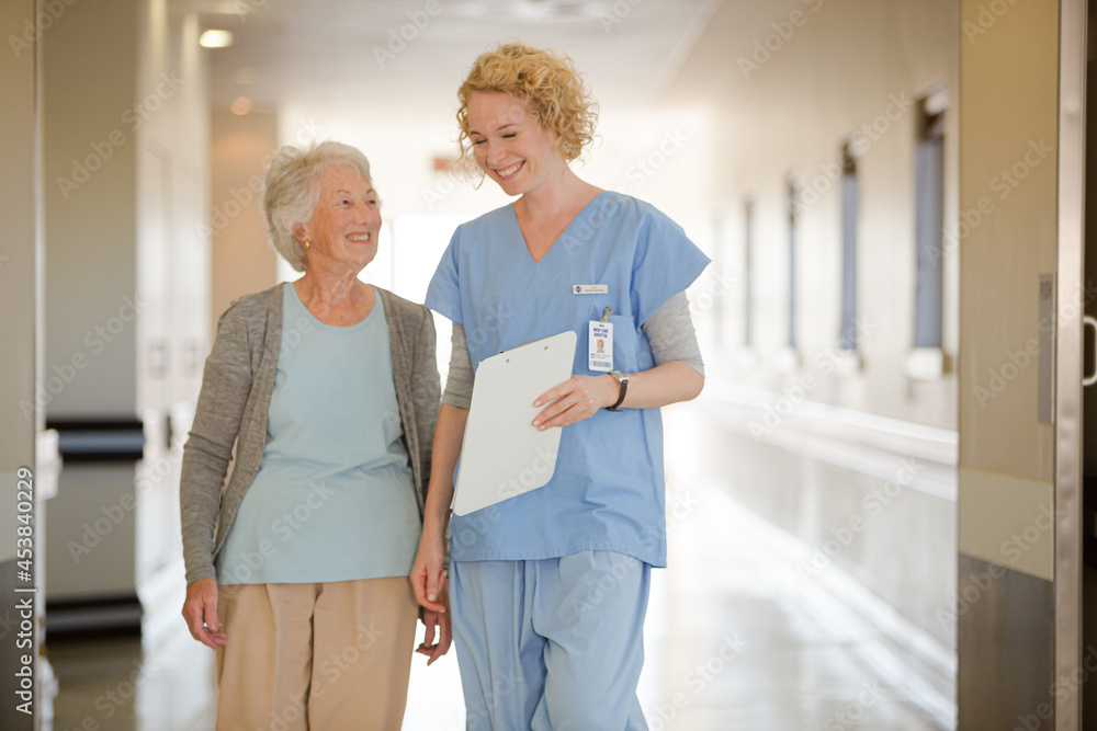 Obraz premium Nurse and senior patient talking in hospital corridor