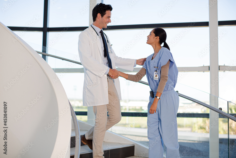 Obraz premium Doctor and nurse handshaking on hospital staircase