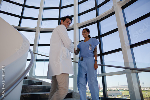 Doctor and nurse handshaking on hospital staircase