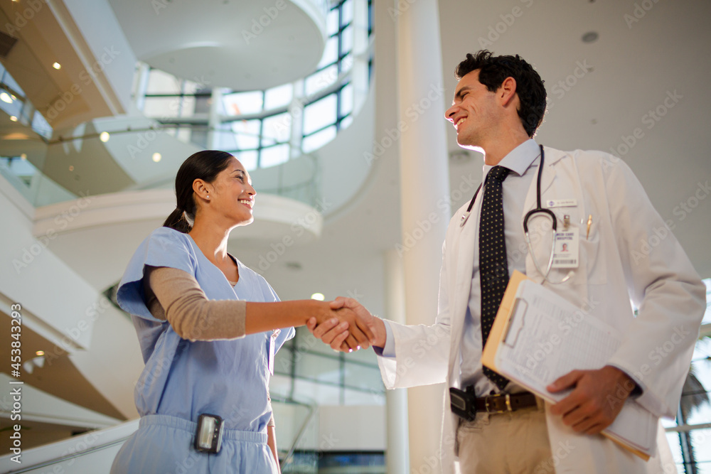 Doctor and nurse handshaking in hospital