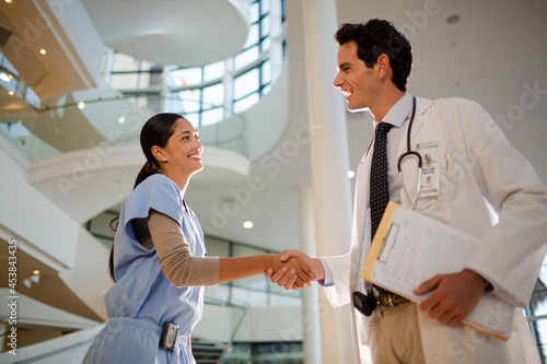 Doctor and nurse handshaking in hospital