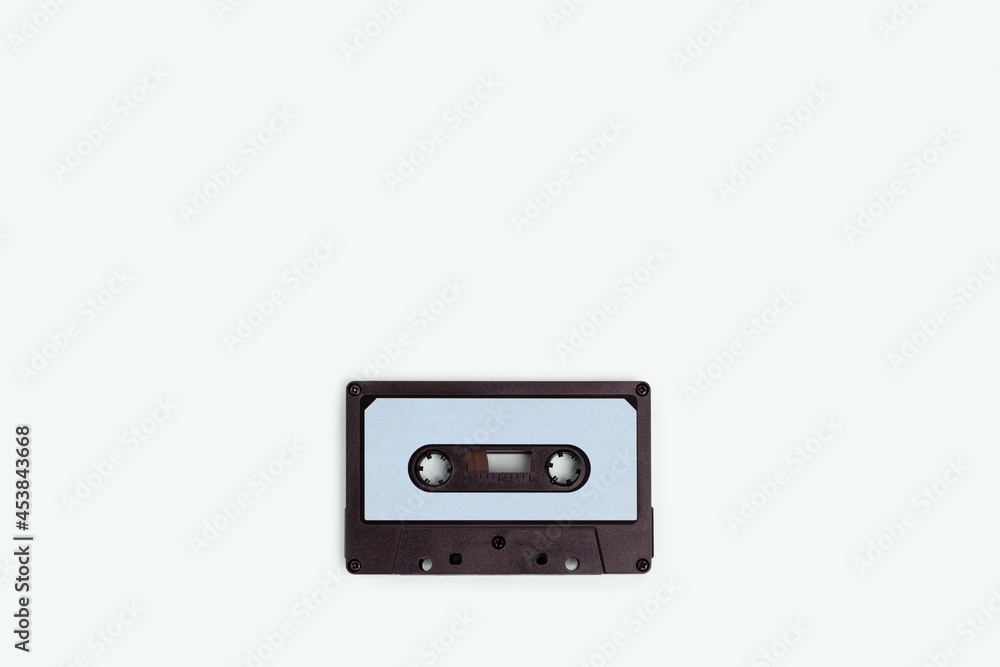 Cassette tape on a blue pastel background. Minimalistic composition with copyspace.
