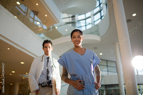 Portrait of smiling doctor and nurse in hospital atrium