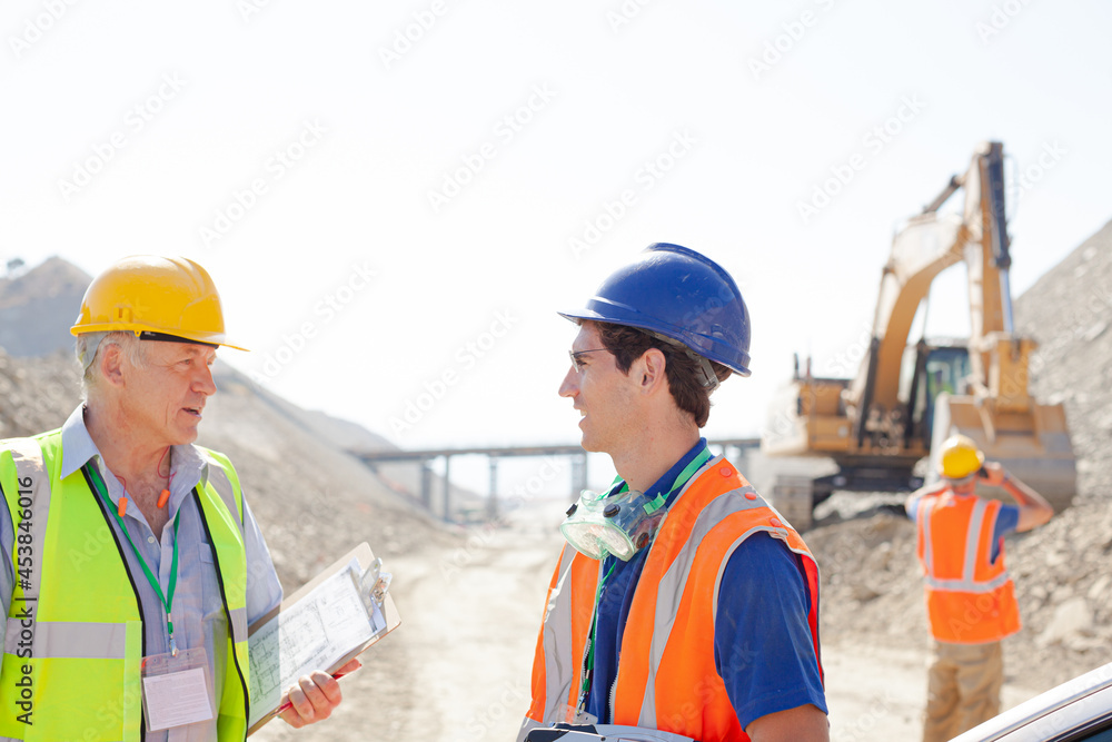 Business people reading blueprints in quarry