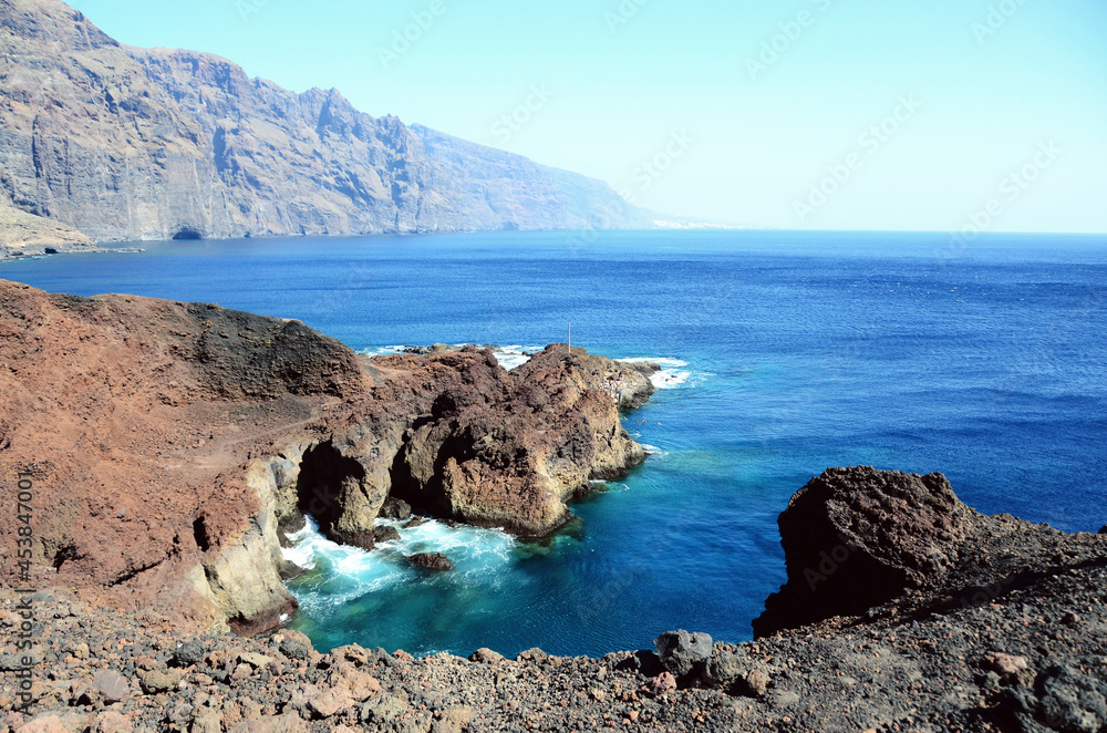 Naklejka premium TENERIFE, SPAIN: Scenic seashore view of Los Gigantes ancient rocks with blue sea waters