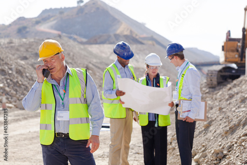 Business people and workers talking in quarry