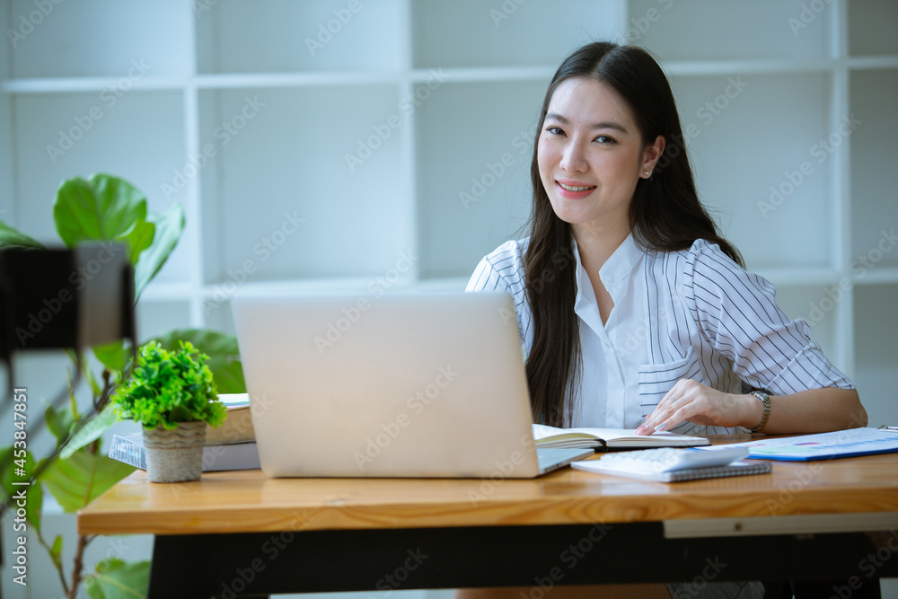 Portrait of Beautiful businesswoman sitting at desk and working with laptop computer. Portrait of Beautiful businesswoman sitting at desk and working with laptop computer.