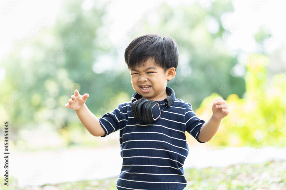 Cheerful Toddler little boy playing outdoor. Asian little child kid having fun, enjoy, relaxing on green grass in the park. Kid, play, field trips and education concept Cheerful Toddler little boy playing outdoor. Asian little child kid having fun, enjoy, relaxing on green grass in the park. Kid, play, field trips and education concept