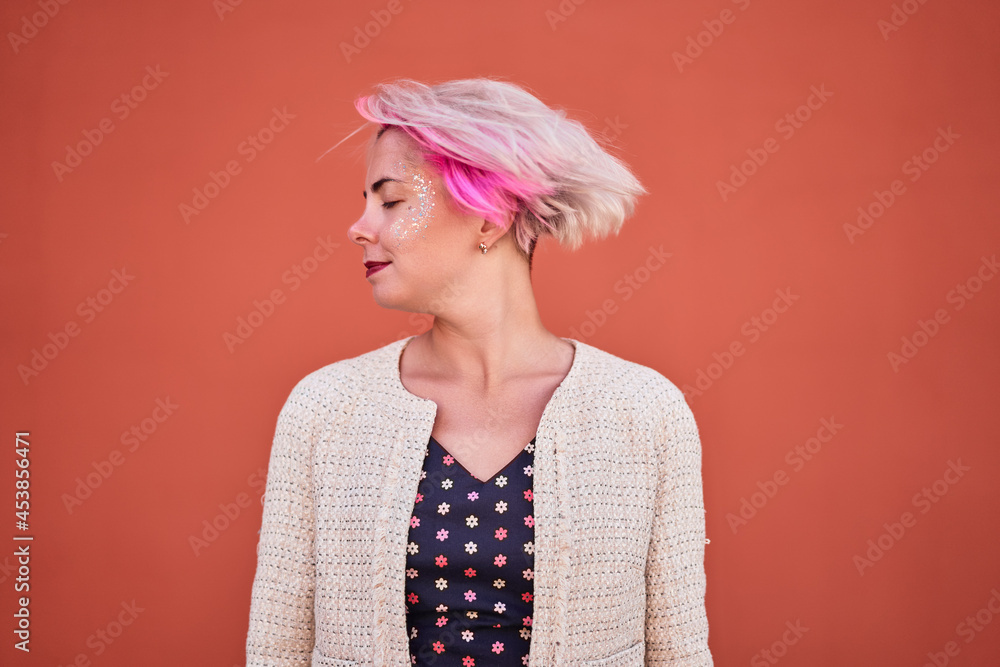 Content informal woman throwing dyed hair in city Content informal woman throwing dyed hair in city
