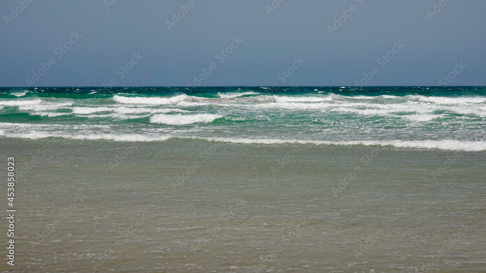 Starker Wellengang an der Atlantikküste, stürmische hohe Wellen am Strand bei schönem Wetter Starker Wellengang an der Atlantikküste, stürmische hohe Wellen am Strand bei schönem Wetter