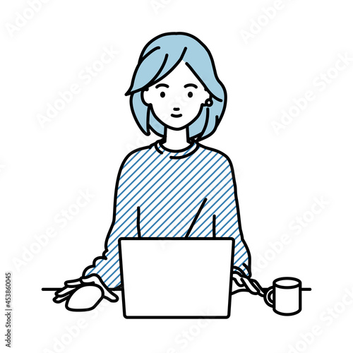 デスクで座ってPCを使っているリモートワークの女性