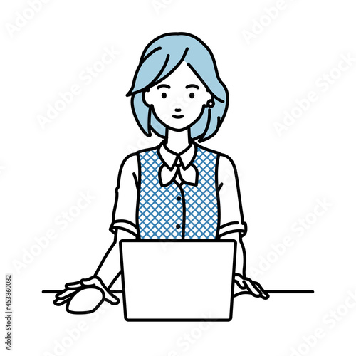デスクで座ってPCを使っている事務員制服の女性
