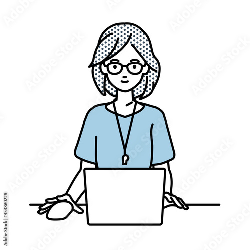 デスクで座ってPCを使っている教師の女性
