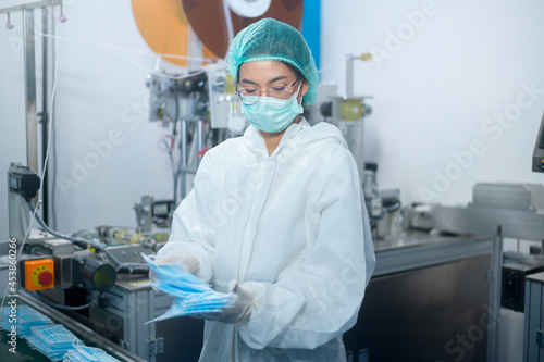 Workers producing surgical mask in modern factory  Covid-19 protection and medical concept.